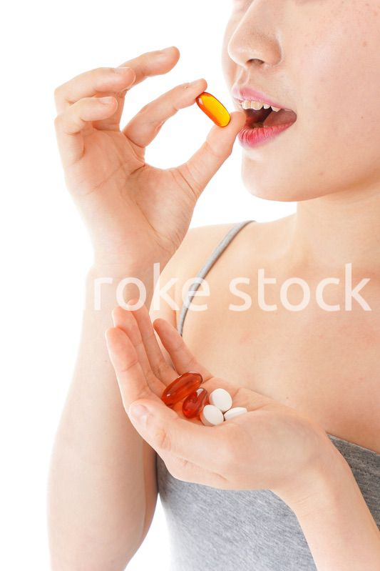 薬・サプリメントを服用する若い女性