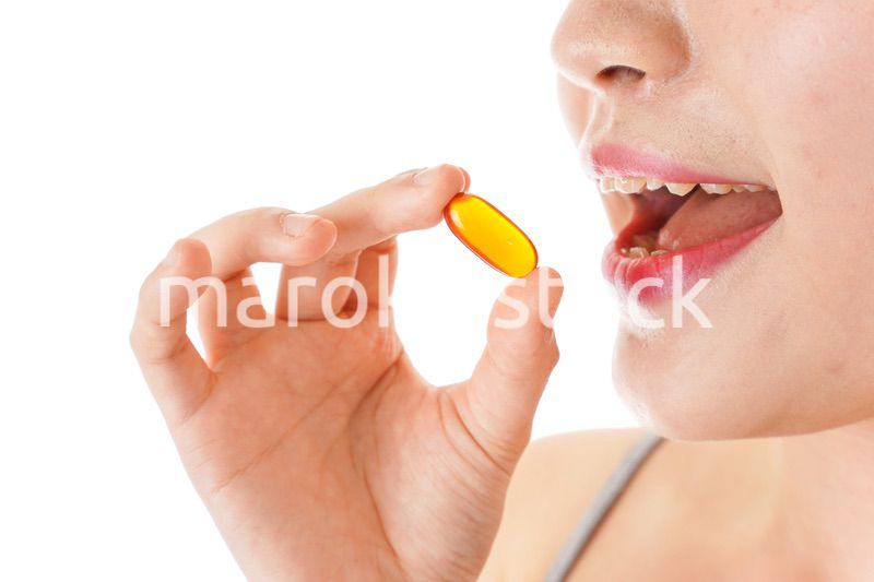 薬・サプリメントを服用する若い女性