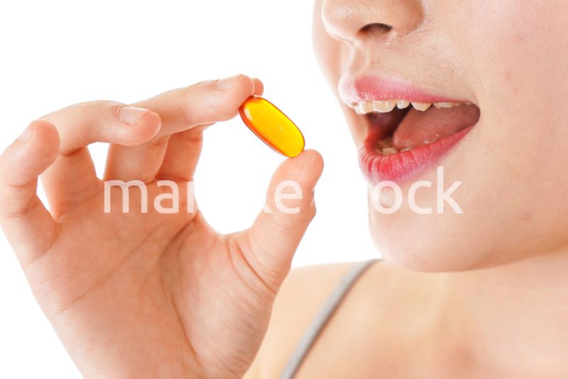 薬・サプリメントを服用する若い女性