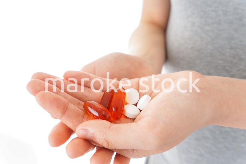 薬・サプリメントを服用する若い女性