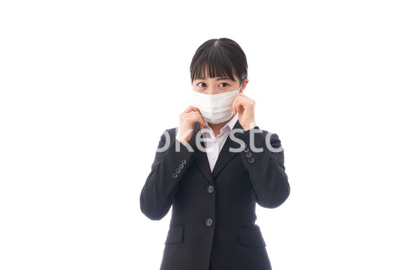 花粉症・風邪・インフルエンザに苦しみマスクをする若い女性