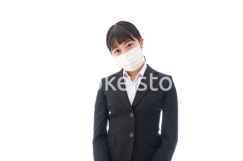 花粉症・風邪・インフルエンザに苦しみマスクをする若い女性