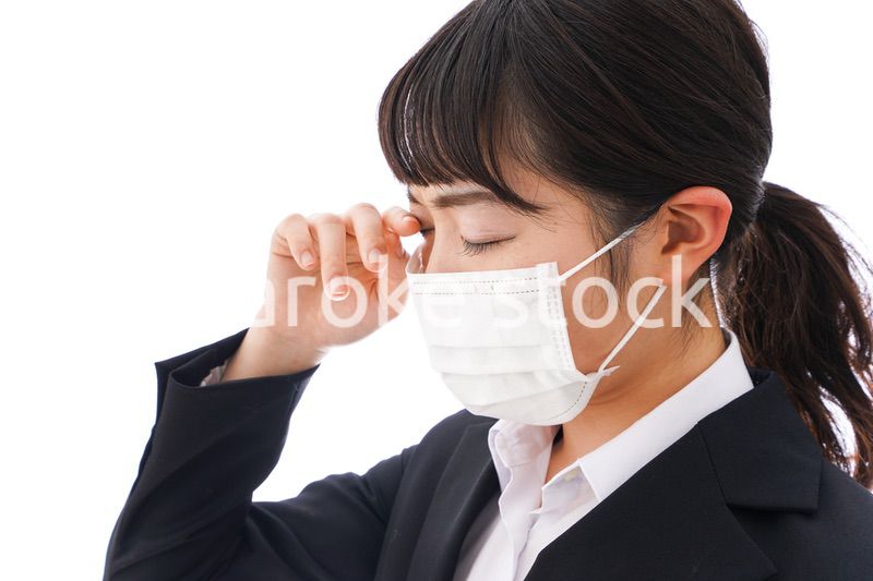 花粉症・風邪・インフルエンザに苦しみマスクをする若い女性