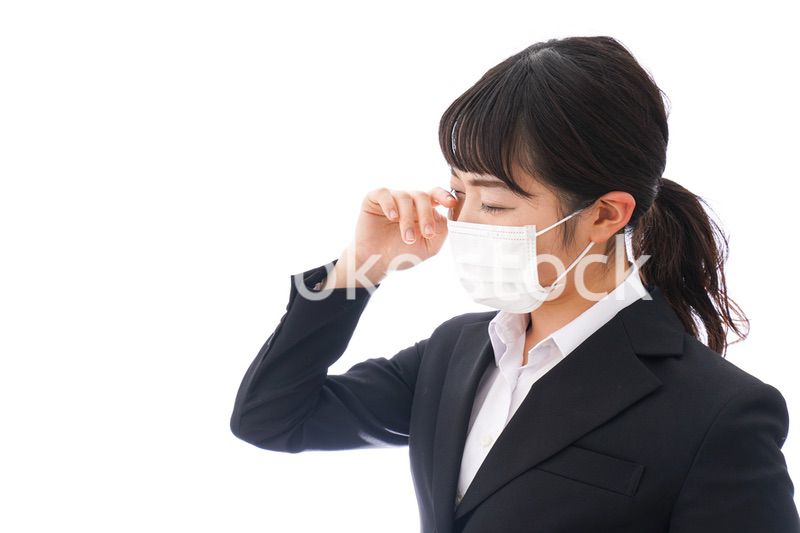 花粉症・風邪・インフルエンザに苦しみマスクをする若い女性