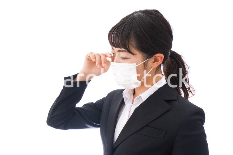 花粉症・風邪・インフルエンザに苦しみマスクをする若い女性