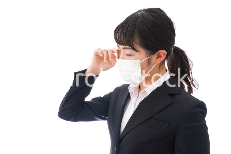 花粉症・風邪・インフルエンザに苦しみマスクをする若い女性