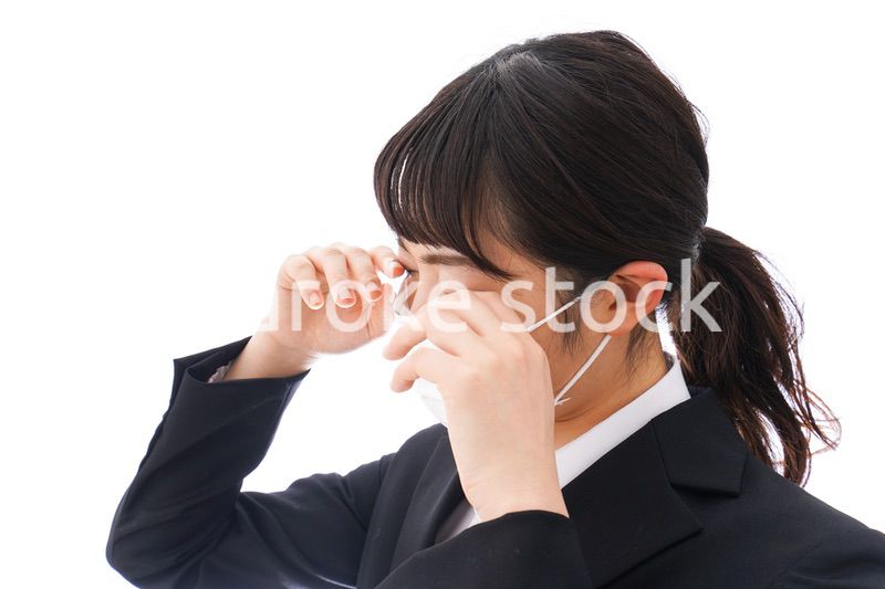 花粉症・風邪・インフルエンザに苦しみマスクをする若い女性