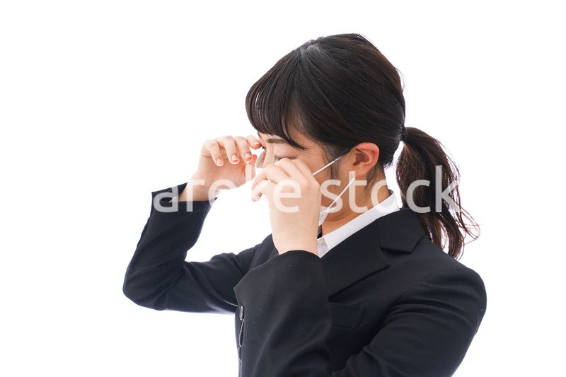 花粉症・風邪・インフルエンザに苦しみマスクをする若い女性