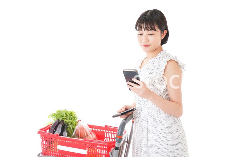 スーパーで食料品を調べる若い女性