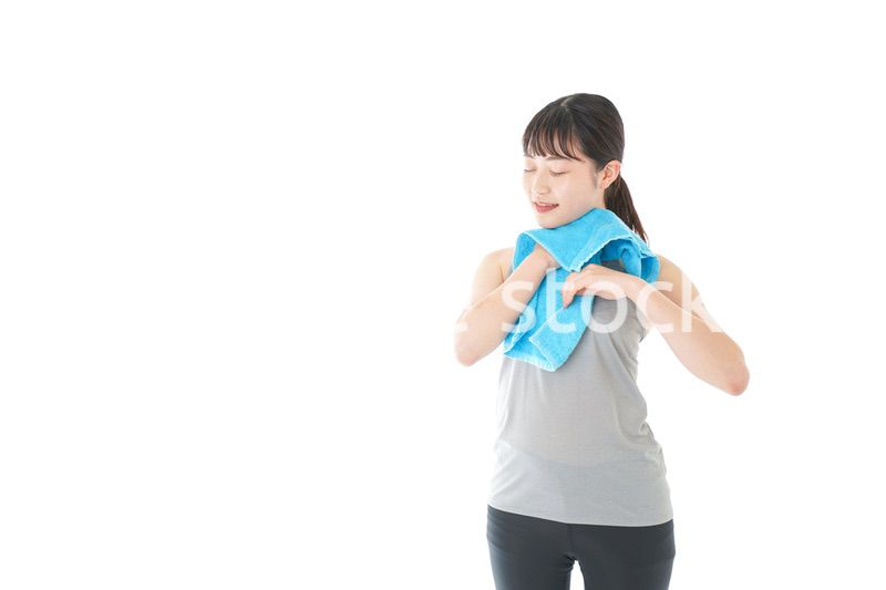汗を拭くスポーツウェアの女性