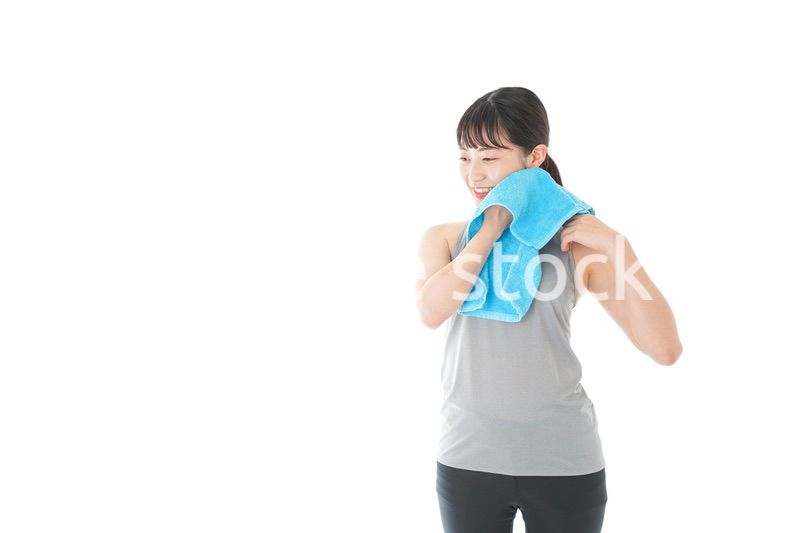 汗を拭くスポーツウェアの女性