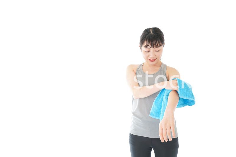 汗を拭くスポーツウェアの女性