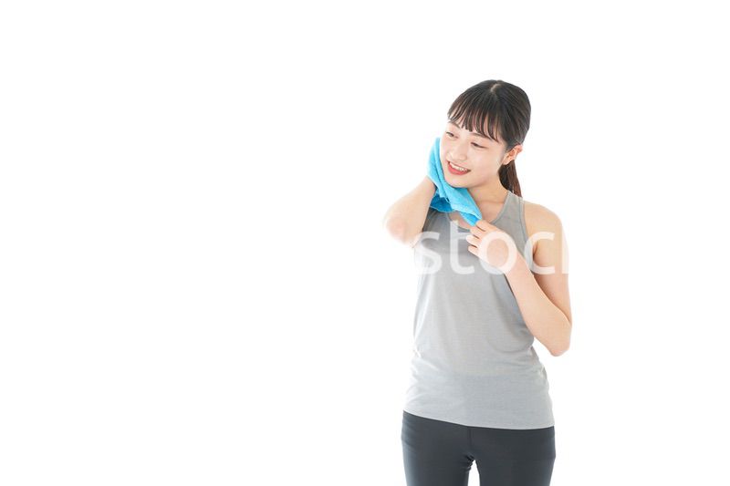 汗を拭くスポーツウェアの女性