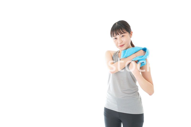 汗を拭くスポーツウェアの女性