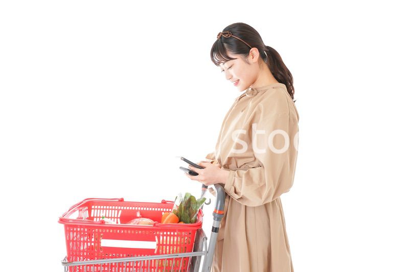 スーパーで食品の原産地を調べる若い女性