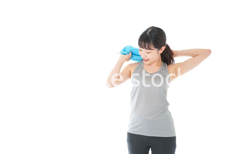 汗を拭くスポーツウェアの女性