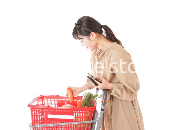 スーパーで食品の原産地を調べる若い女性