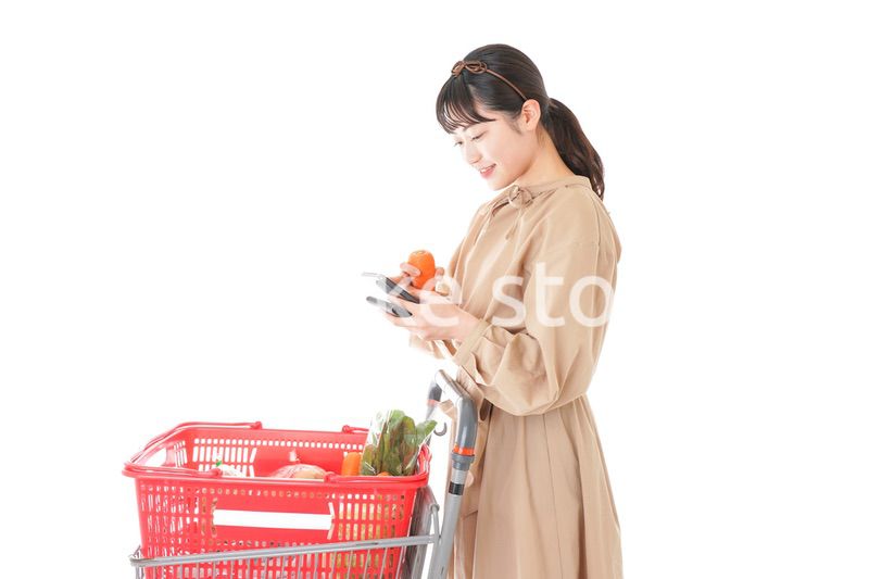 スーパーで食品の原産地を調べる若い女性