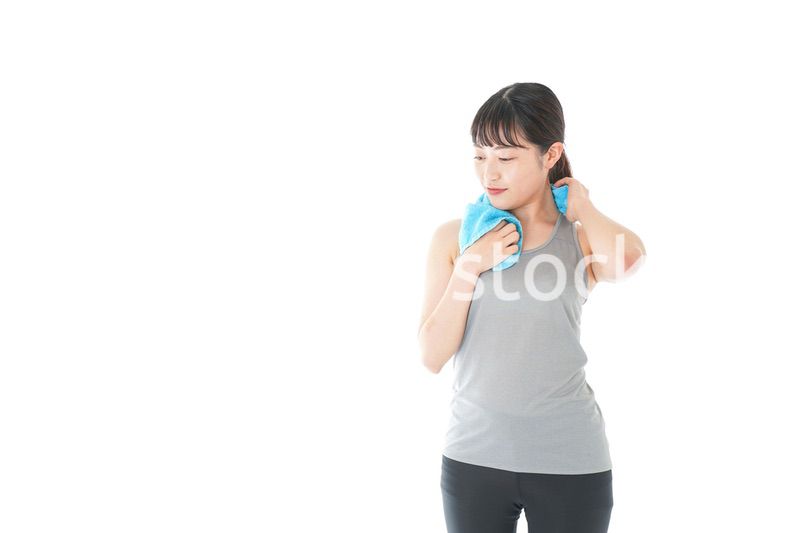 汗を拭くスポーツウェアの女性