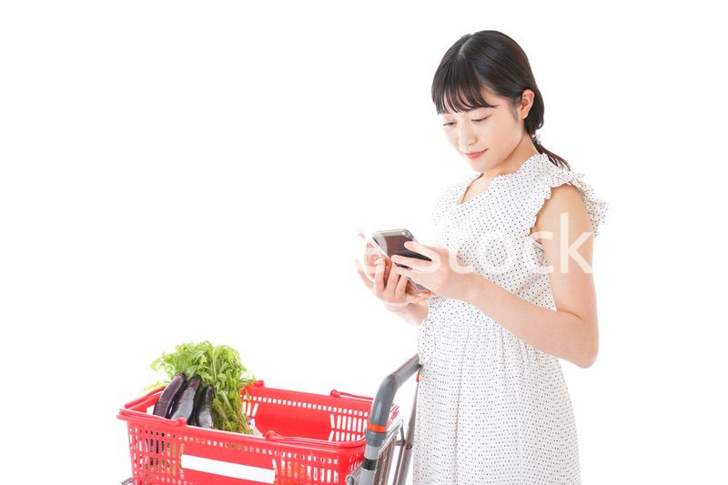 スーパーで食料品を調べる若い女性