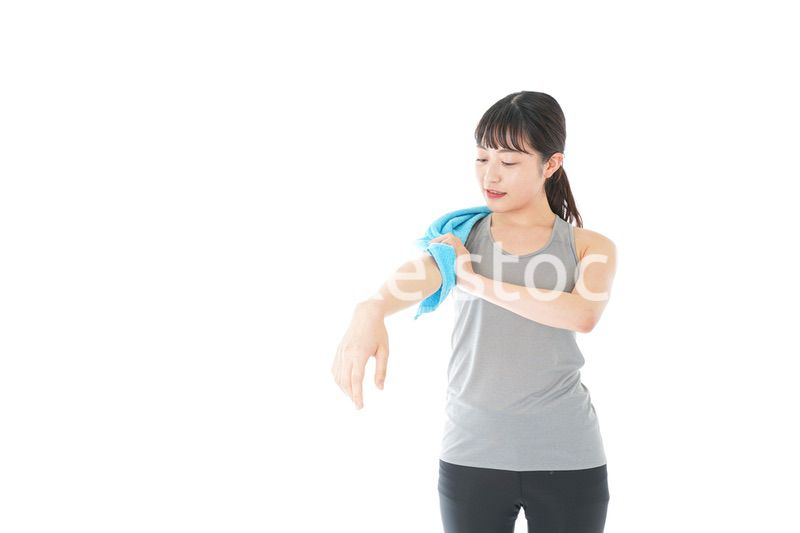 汗を拭くスポーツウェアの女性