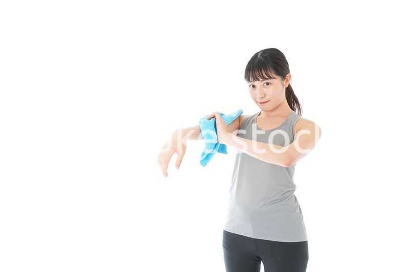 汗を拭くスポーツウェアの女性