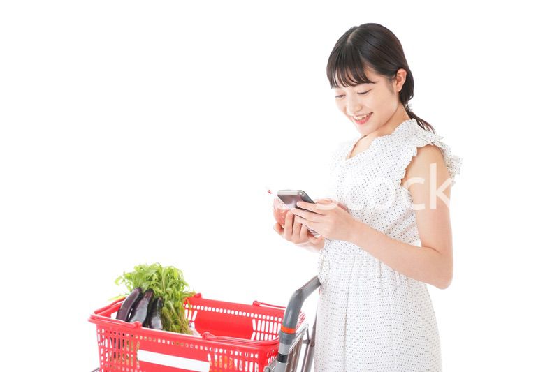 スーパーで食料品を調べる若い女性
