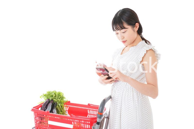 スーパーで食料品を調べる若い女性