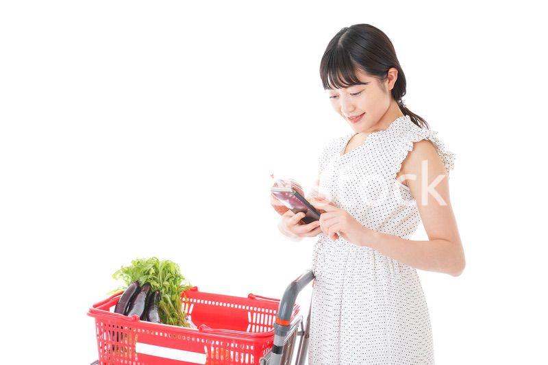 スーパーで食料品を調べる若い女性