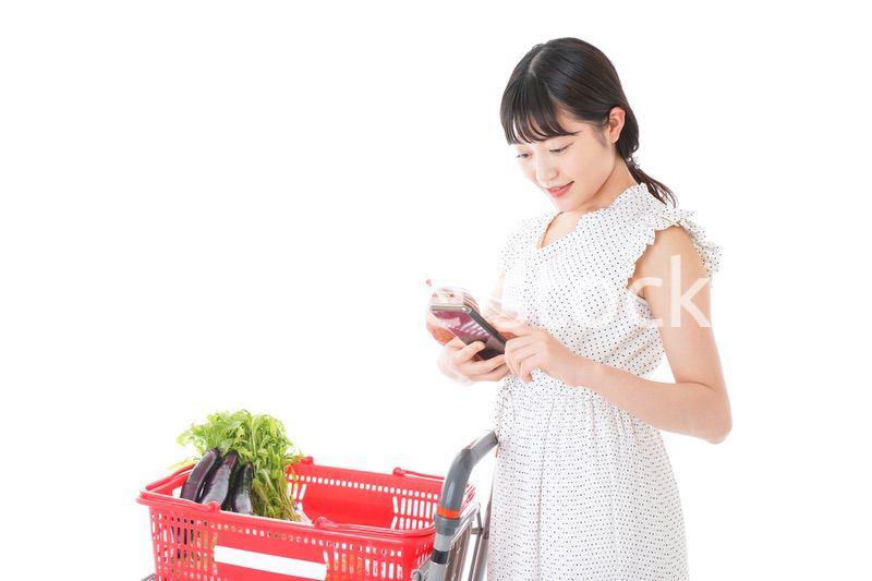 スーパーで食料品を調べる若い女性