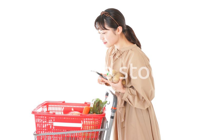 スーパーで食品の原産地を調べる若い女性