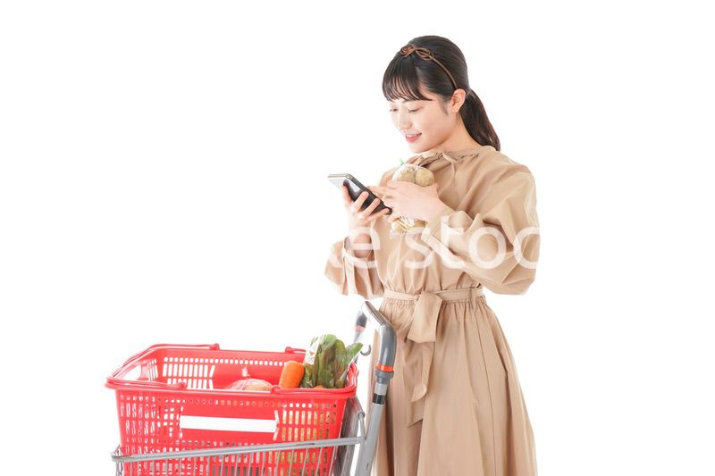 スーパーで食品の原産地を調べる若い女性