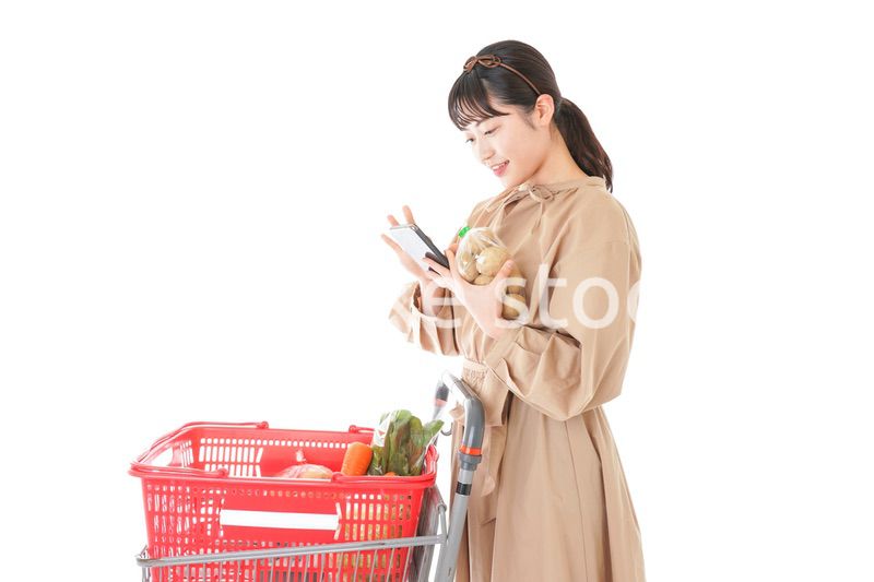 スーパーで食品の原産地を調べる若い女性