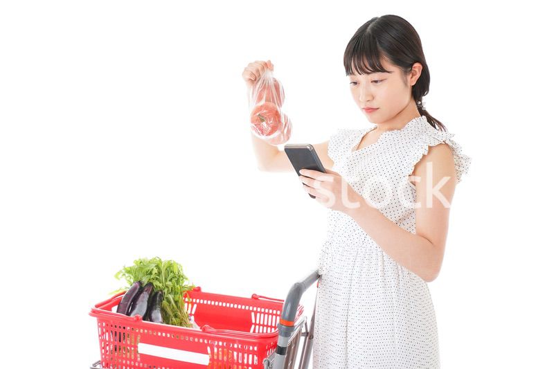 スーパーで食料品を調べる若い女性