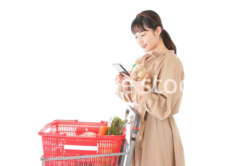 スーパーで食品の原産地を調べる若い女性