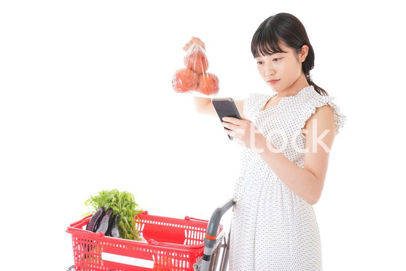 スーパーで食料品を調べる若い女性