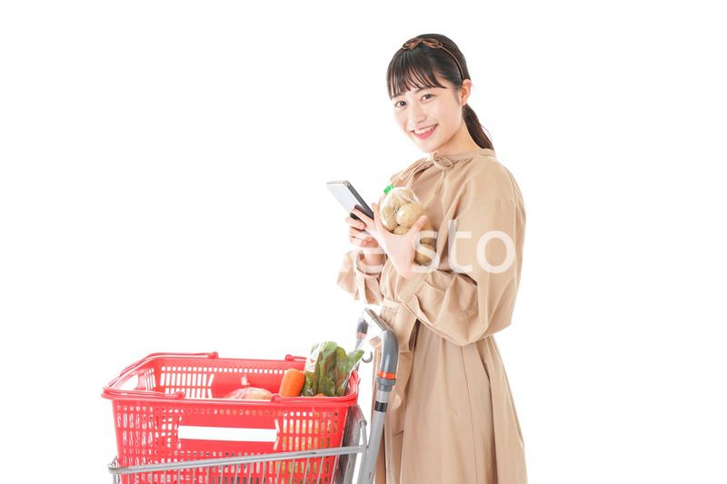 スーパーで食品の原産地を調べる若い女性