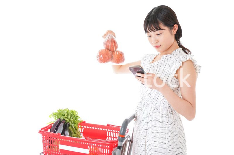 スーパーで食料品を調べる若い女性