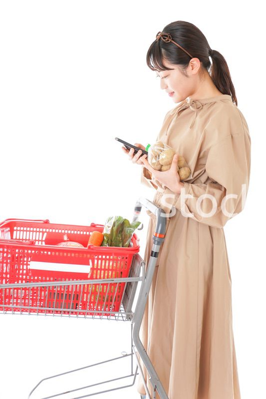 スーパーで食品の原産地を調べる若い女性