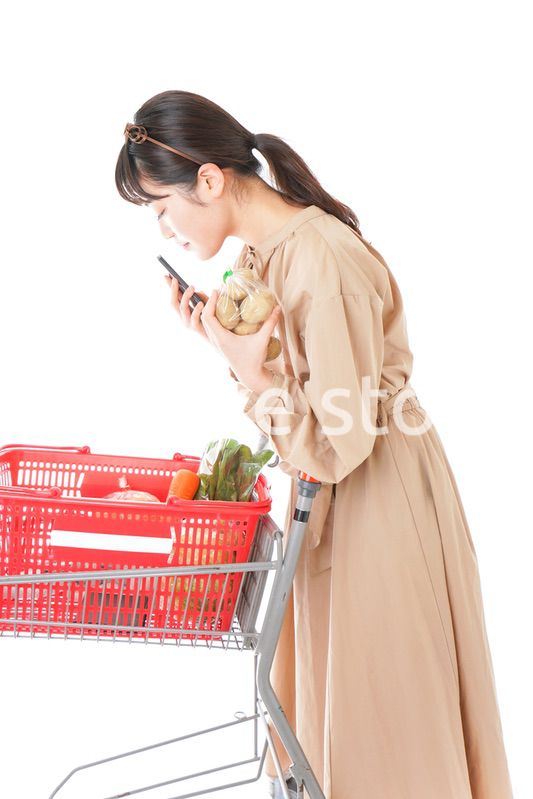 スーパーで食品の原産地を調べる若い女性
