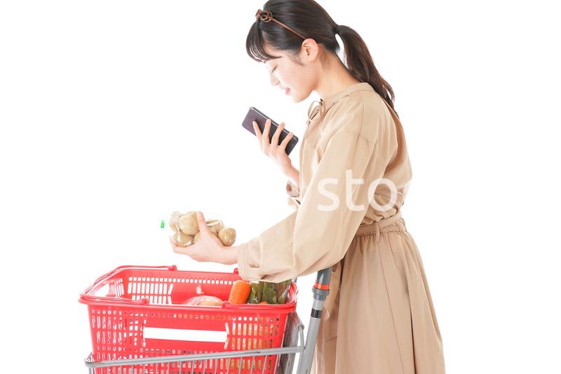 スーパーで食品の原産地を調べる若い女性