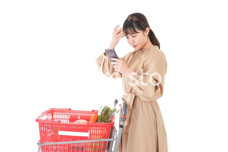 スーパーで食品の原産地を調べる若い女性
