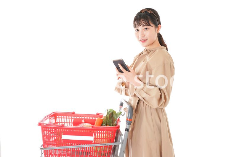 スーパーで食品の原産地を調べる若い女性