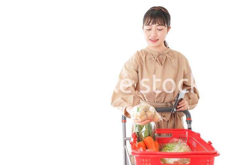 スーパーで食品の原産地を調べる若い女性