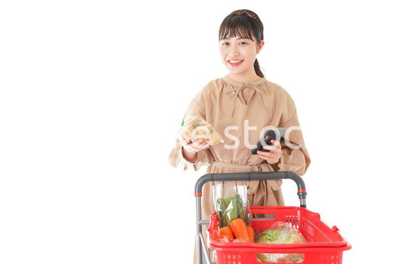 スーパーで食品の原産地を調べる若い女性