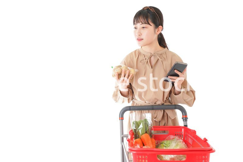 スーパーで食品の原産地を調べる若い女性