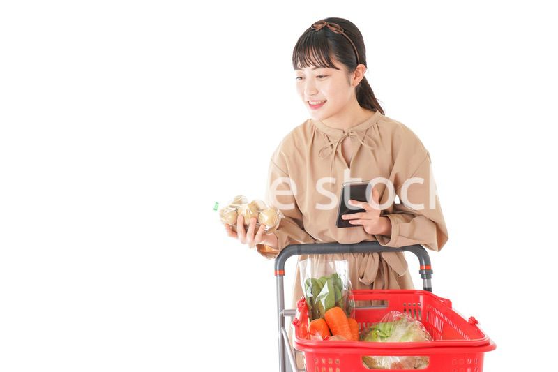 スーパーで食品の原産地を調べる若い女性