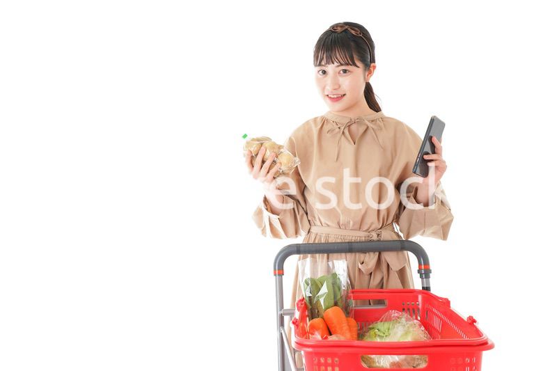 スーパーで食品の原産地を調べる若い女性