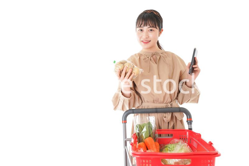 スーパーで食品の原産地を調べる若い女性