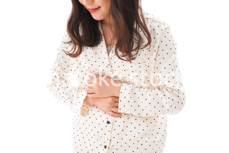腹痛で苦しむ若い女性